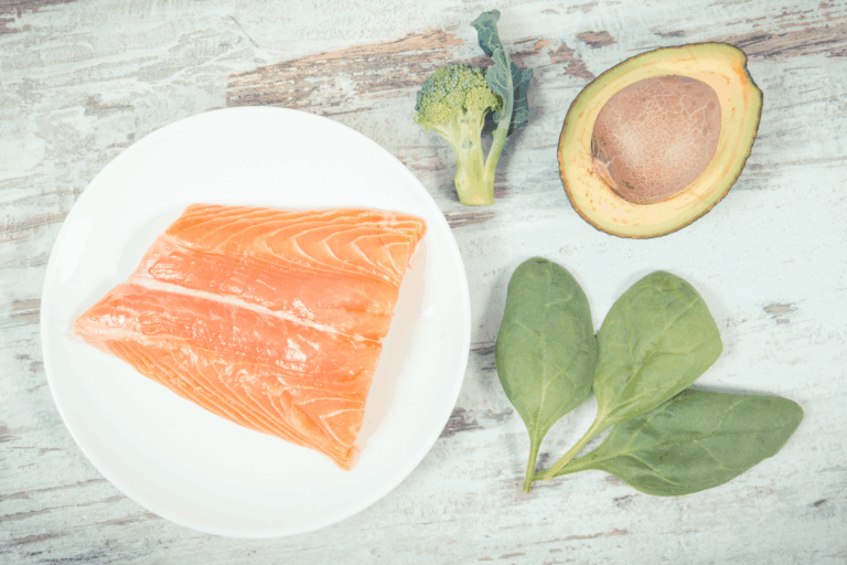 Piatto con salmone, avocado, uova e verdure verdi — dieta chetogenica menopausa